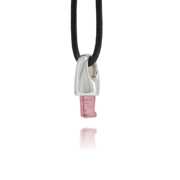 Necklace with a sterling silver and natural pink tourmaline crystal pendant on a black cord against a white background