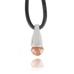 Front view of necklace with a silver and garnet crystal pendant on a black cord against a white background
