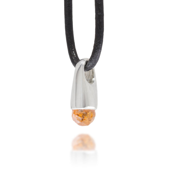 side view of a necklace with a silver pendant featuring an orange stone on a white background