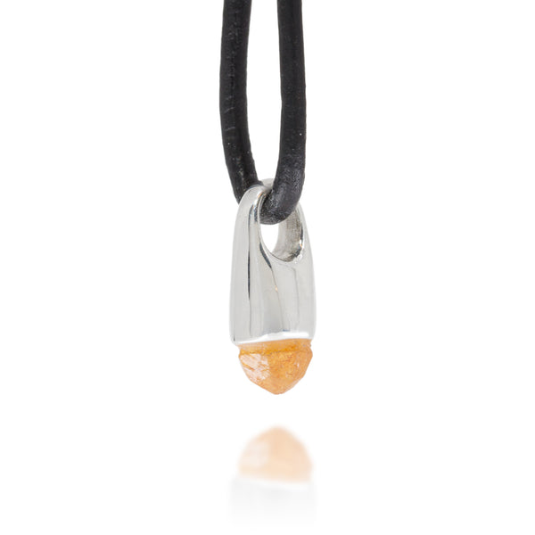 Necklace with a silver and orange pendant on a black cord against a white background